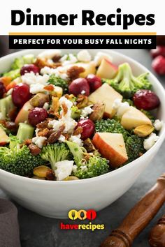 a white bowl filled with broccoli, apples, cheese and cranberries