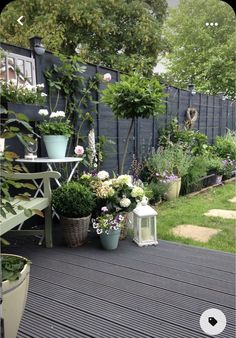 an outdoor patio with potted plants and flowers on the decking area next to it