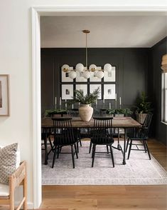 a dining room with black walls and wooden floors