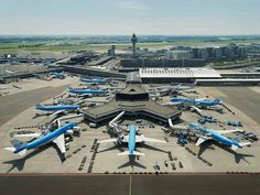 an airport with many airplanes parked on the tarmac and in front of it is a control tower