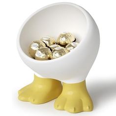 a white bowl filled with chocolates sitting on top of a yellow ducky legs