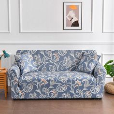 a blue and white couch sitting in a living room next to a table with a plant on it