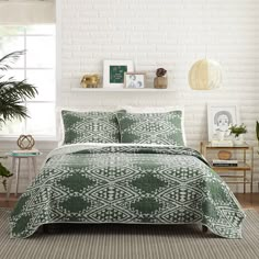 a bed in a room with white brick walls and green bedspread, potted plants on the side