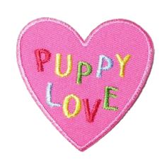 a pink heart with the words puppy love written on it's side and an embroidered patch in the shape of a heart