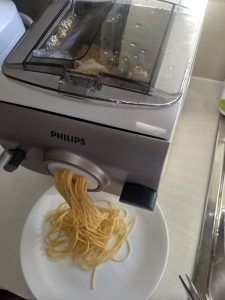 a plate with noodles is being pulled into a food processor