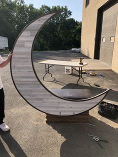 a woman standing in front of a table with a crescent shaped object on top of it