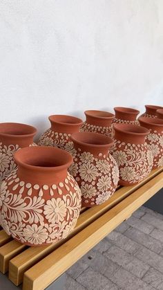 several vases are lined up on a wooden bench