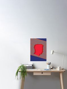 a desk with a plant on it next to a wall mounted art piece in the shape of a red heart