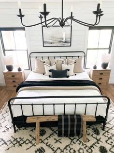 a bedroom with a bed, dressers and chandelier in the middle of it