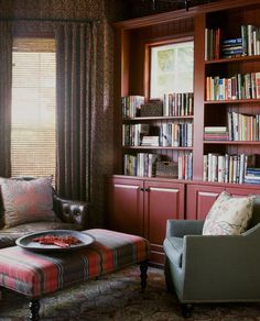 a living room filled with furniture and bookshelves covered in lots of bookcases