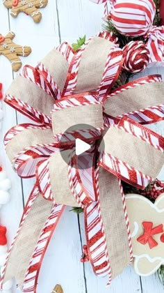 a red and white christmas wreath with candy canes on it next to other holiday decorations