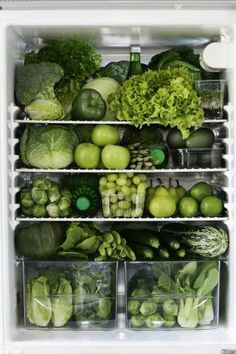 an open refrigerator filled with lots of green vegetables