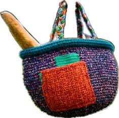 a small purse with an orange pocket on it's side, hanging from a hook