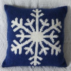 a blue and white knitted snowflake pillow