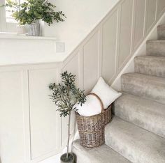 a basket sitting on the stairs next to a planter with a pillow in it