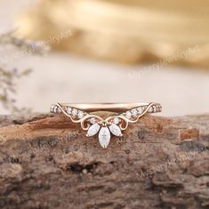 a close up view of a gold ring with leaves on it, sitting on top of a piece of wood