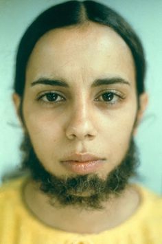 a man with a beard and yellow shirt