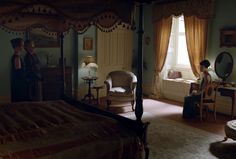 a woman standing in a bedroom next to a bed