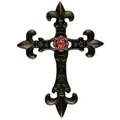 an ornate metal cross with a red jewel on it