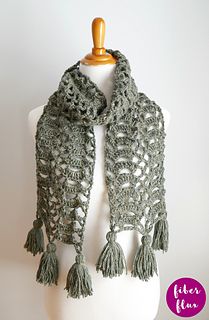 a crocheted scarf with tassels on a mannequin