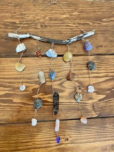 a wooden table topped with lots of different types of beads and chains hanging from it's sides