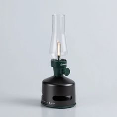 a small lamp with a light bulb on top of it's base, sitting on a white surface