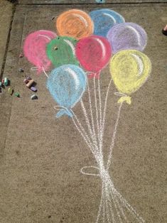 some balloons are drawn on the sidewalk with chalk