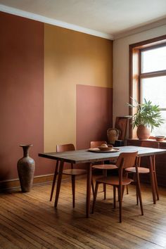 A dining room with an earthy two-tone accent wall and warm, natural decor. Earthy Dining Room, Save For Later