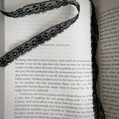 an open book with black lace on it