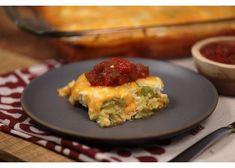 a black plate topped with an omelet covered in salsa