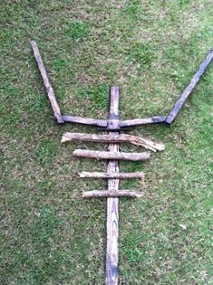 a cross made out of logs laying in the grass