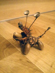 an odd looking object sitting on top of a hard wood floor with spoons sticking out of it