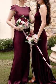 two women in long dresses standing next to each other