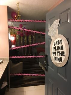 the door is decorated with pink streamers and an acrylic sign that says, last fling by the ring