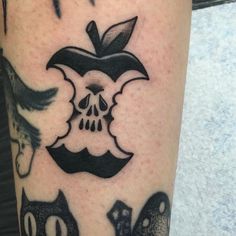 an apple with skulls and cats on it's legs is seen in this tattoo design