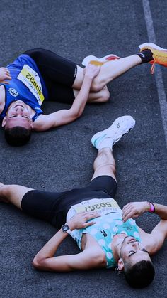 two men laying on the ground with their feet in the air