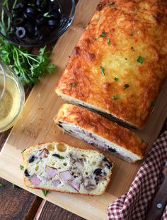 a loaf of bread sitting on top of a cutting board next to a glass of wine