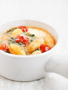 a white bowl filled with food on top of a table