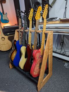 several guitars are lined up in a rack