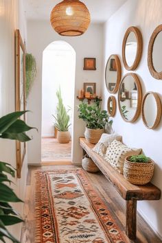 a hallway with several mirrors and plants on the wall, along with a wooden bench