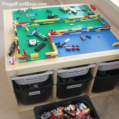 a lego table with bins and toy cars on it