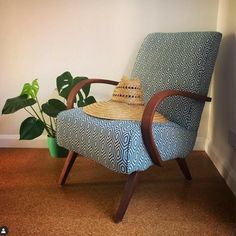 a chair with a hat on it in front of a potted plant