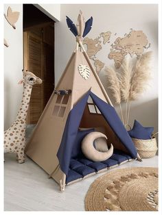 a child's teepee tent and giraffes are in the room