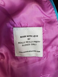 a label on the back of a pink jacket that says made with love by really pretty blonde girls