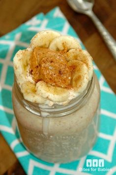 a glass jar filled with food sitting on top of a blue and white napkin next to a spoon