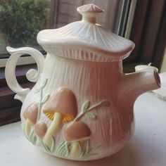 a ceramic tea pot sitting on top of a window sill