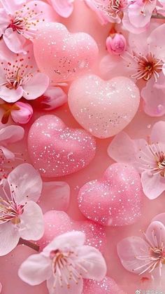 some pink flowers and hearts are in the air with water droplets on them, as if they were floating or floating