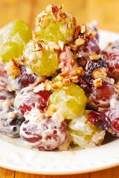 grapes and walnuts are mixed together on a plate