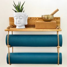 a shelf that has some yoga mats and a potted plant on top of it