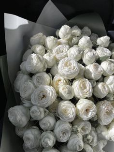 a bunch of white roses in a paper bag